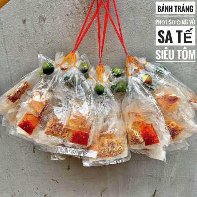 **Bánh Tráng Phơi Sương Vò Sa Tế Muối Tôm – Đậm Đà Hương Vị Tây Ninh** Bánh tráng phơi sương vò sa tế muối tôm là món ăn vặt đặc sản được nhiều người yêu thích bởi hương vị cay mặn hài hòa và độ dẻo mềm đặc trưng. Được làm từ bánh tráng phơi sương chất lượng, sản phẩm giữ được độ dai vừa phải, không quá khô cũng không quá mềm, mang đến cảm giác ngon miệng ngay từ lần thưởng thức đầu tiên. Điểm nhấn của bánh tráng phơi sương vò nằm ở lớp sa tế thơm lừng kết hợp cùng muối tôm đậm vị. Từng miếng bánh được trộn đều gia vị, thấm đẫm vị cay nhẹ của ớt, vị mặn ngọt cân bằng và hương thơm hấp dẫn. Đây là lựa chọn lý tưởng cho những buổi tụ họp bạn bè, xem phim hoặc làm món ăn vặt hằng ngày. Sản phẩm được chế biến từ nguyên liệu tuyển chọn, đảm bảo an toàn vệ sinh thực phẩm và giữ trọn hương vị đặc sản Tây Ninh. Nếu bạn đang tìm kiếm một món ăn vặt ngon, tiện lợi và đậm đà bản sắc Việt, bánh tráng phơi sương vò sa tế muối tôm chắc chắn sẽ là lựa chọn không thể bỏ qua. 